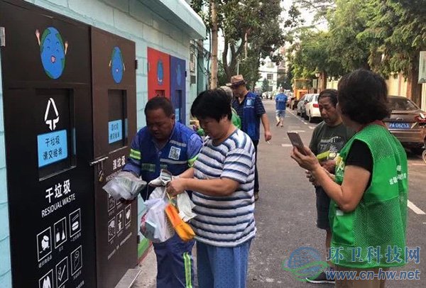 景谷住宅小區(qū)志愿者幫助居民進(jìn)行垃圾分類(lèi)投